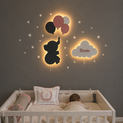 Habitación de bebé con set de 3 lámparas de madera con luz LED: elefantito con globos y nube personalizada con nombre. Decoración de pared en tonos oscuros y rosas.