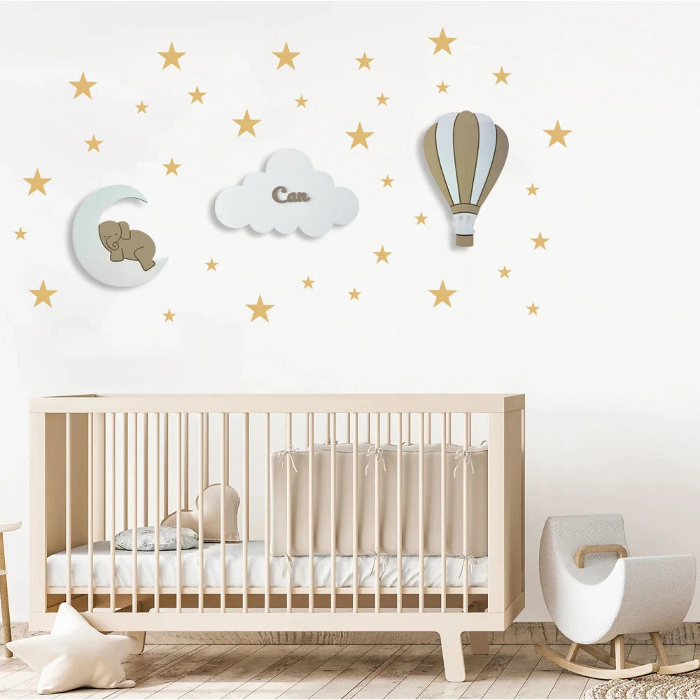 Ejemplo de un set personalizado de 3 lámparas infantiles de madera en colores neutors con elefante sobre la luna, nube con nombre y globo aerostático, pintadas a mano con pintura a base de agua para habitación infantil.