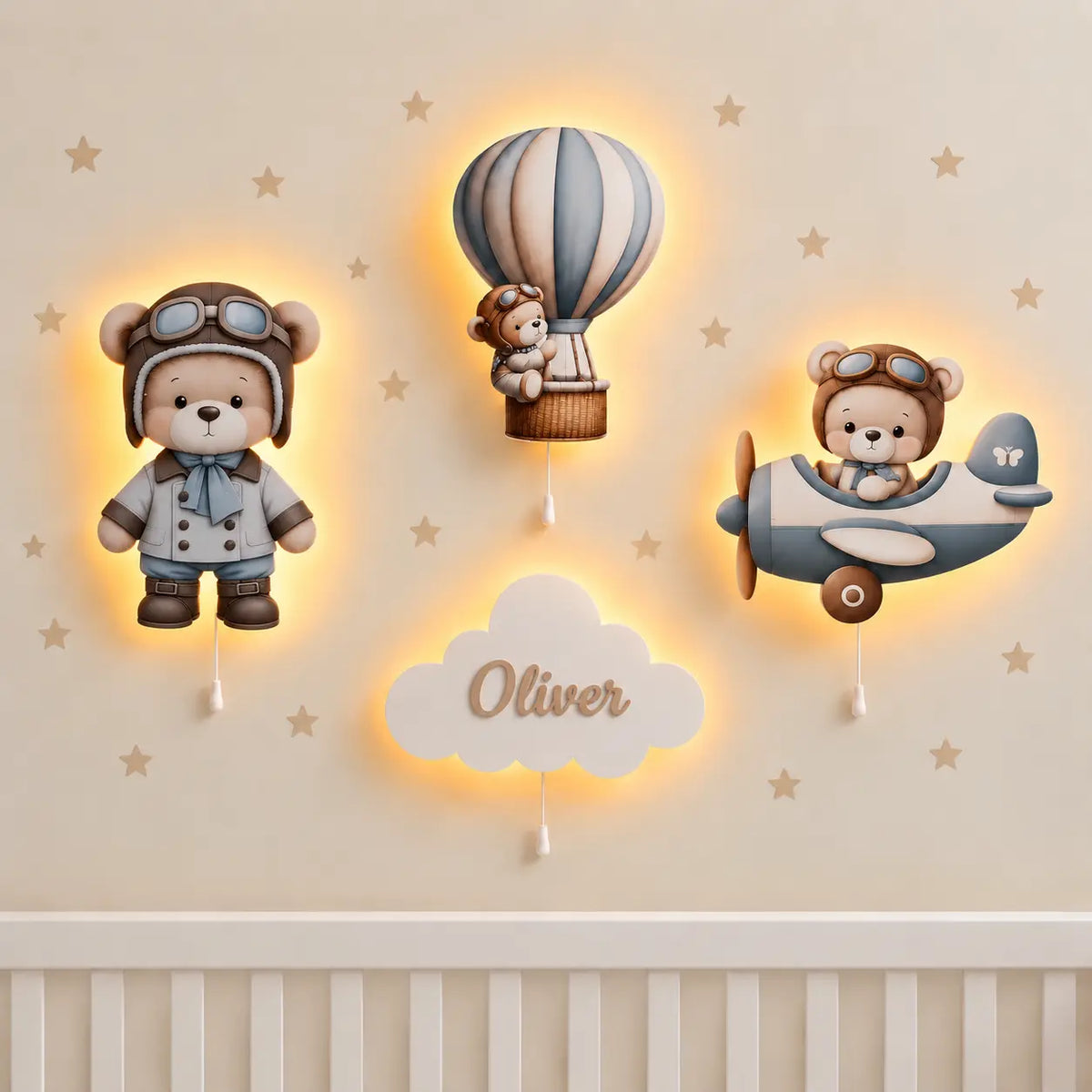 Set de 4 lámparas infantiles de madera Osito volador: osito con gorro de piloto, osito en globo aerostático, osito en avioneta y nube con el nombre Oliver, encendidas en la pared de una habitación de bebé.